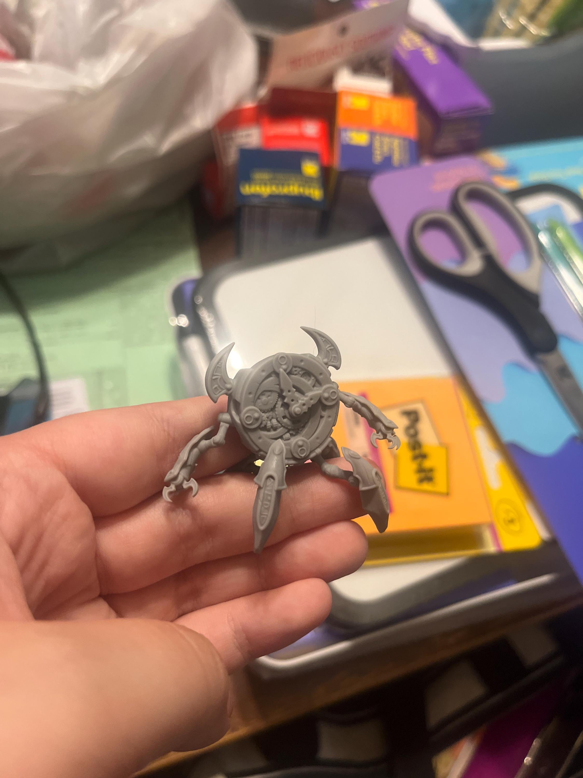 Unpainted clockwork golem miniature held in hand from an Etsy order