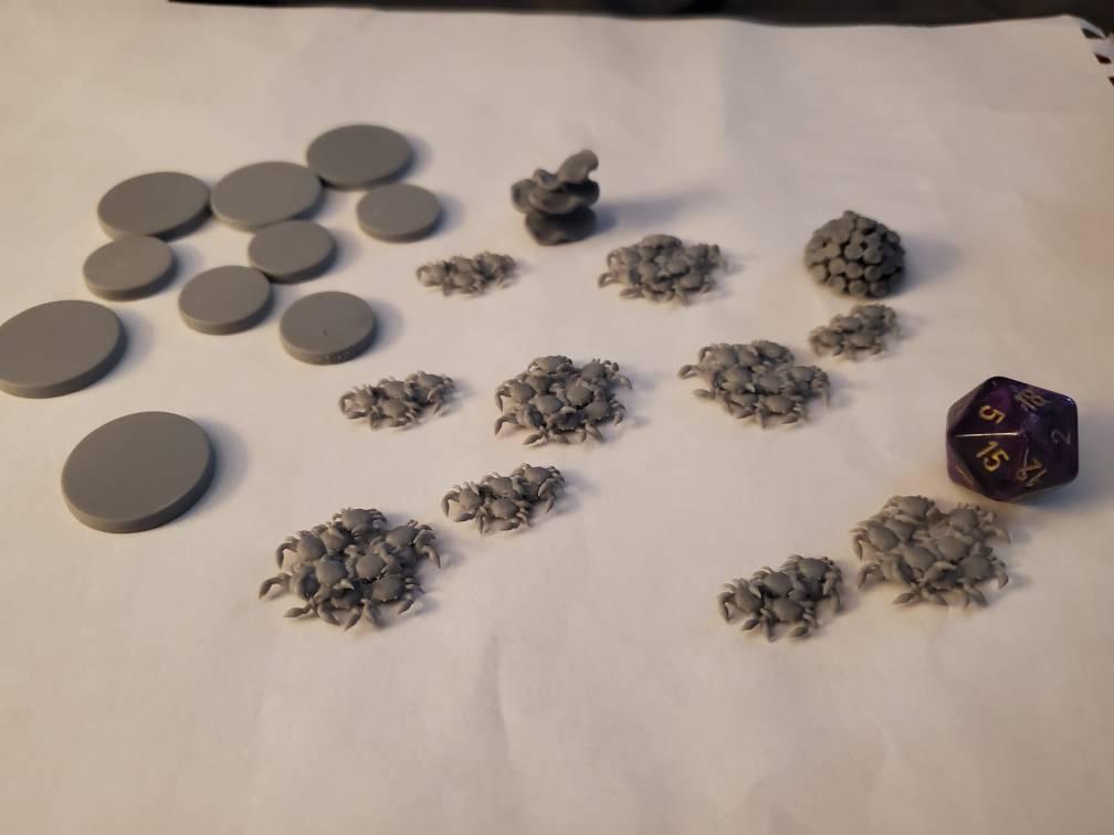 Unpainted crab swarm miniatures from an Etsy order, photographed with a d20